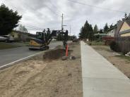The crew is constructing a drainage swale and adding topsoil