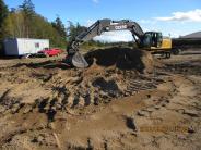 Construction crews finish up preparing the site, clearing old landscaping, etc.